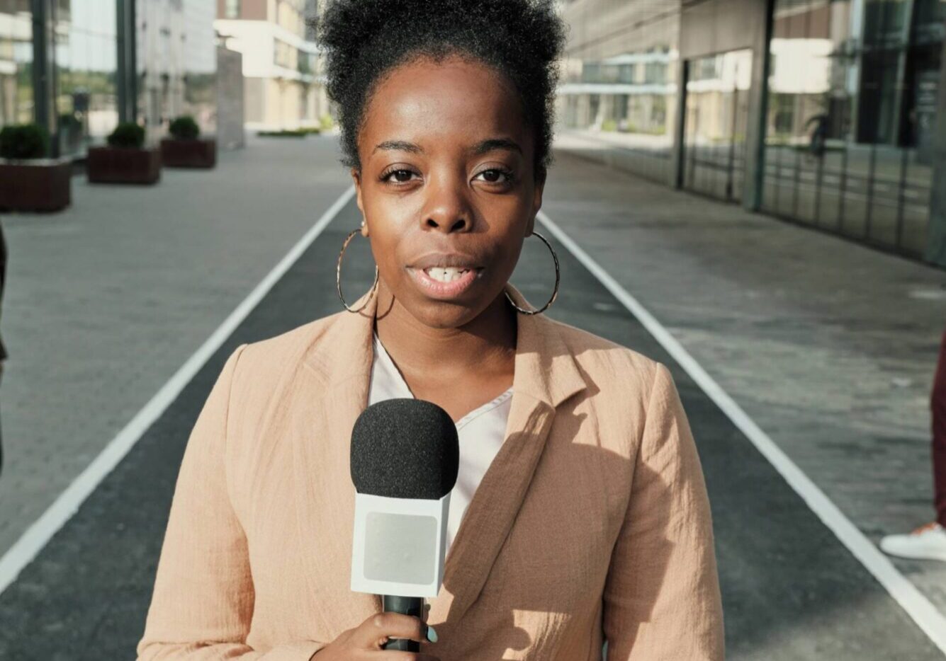Reporter holding microphone on street