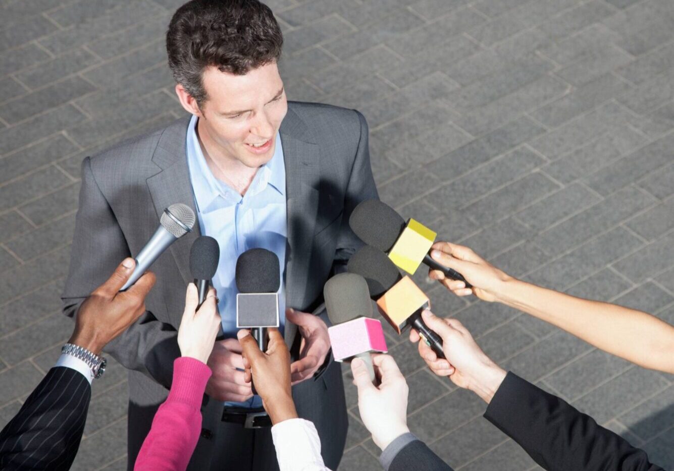 Man speaking to multiple microphones